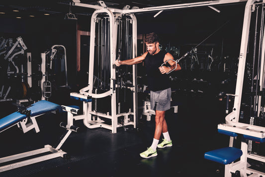 a man performs a pull-up on a gym machine, showcasing strength and fitness.