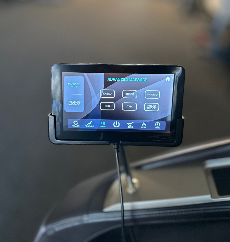 A car interior featuring a tablet mounted on the dashboard, alongside a massage chair for added comfort.
