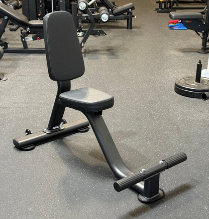 Black tricep seat with footrest on speckled rubber flooring
