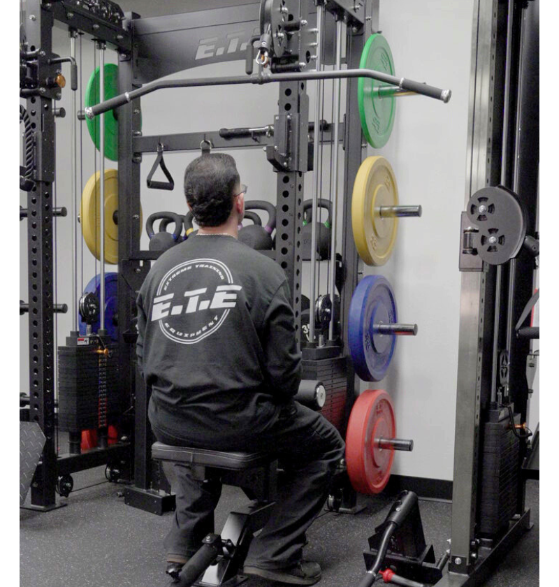 Person using a weight machine in a gym setting.