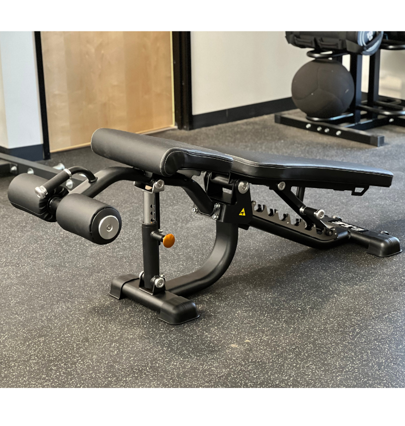 A black adjustable flat exercise bench equipped with a footrest, ideal for supporting various workout positions and exercises.