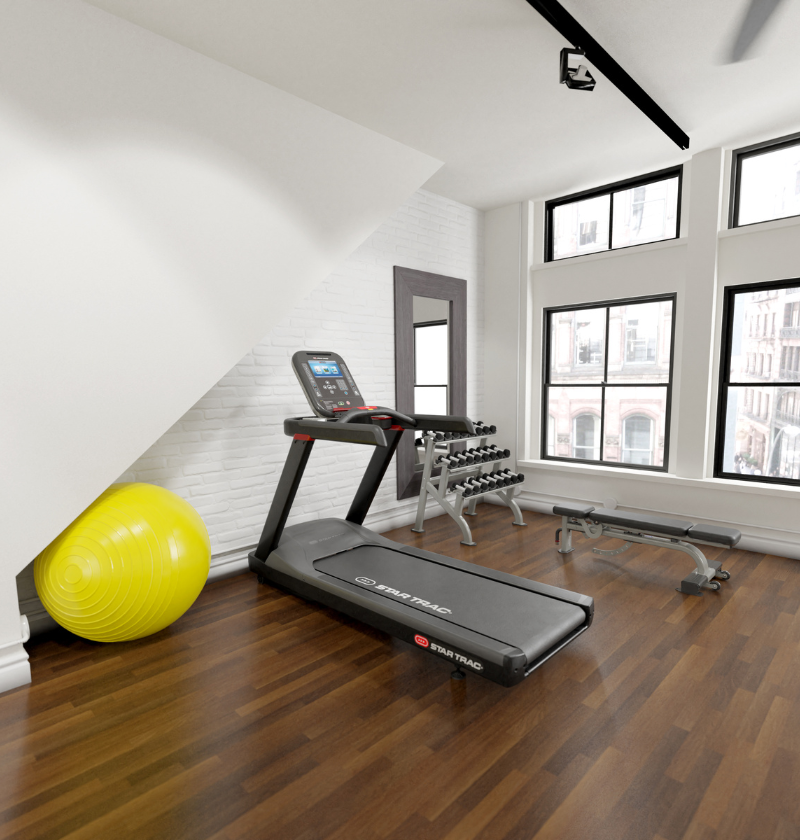 Home gym with treadmill, exercise ball, and weights in a room with large windows.