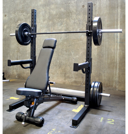 A black 6ft Basic Squat Rack with a pair of spotter arms, j-hooks, and weight peg holders, accompanied by a power bar and an adjustable bench.