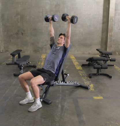 A man performs a dumbbell exercise on an Adjustable Flat Incline Bench PL7328, focusing on strength training.